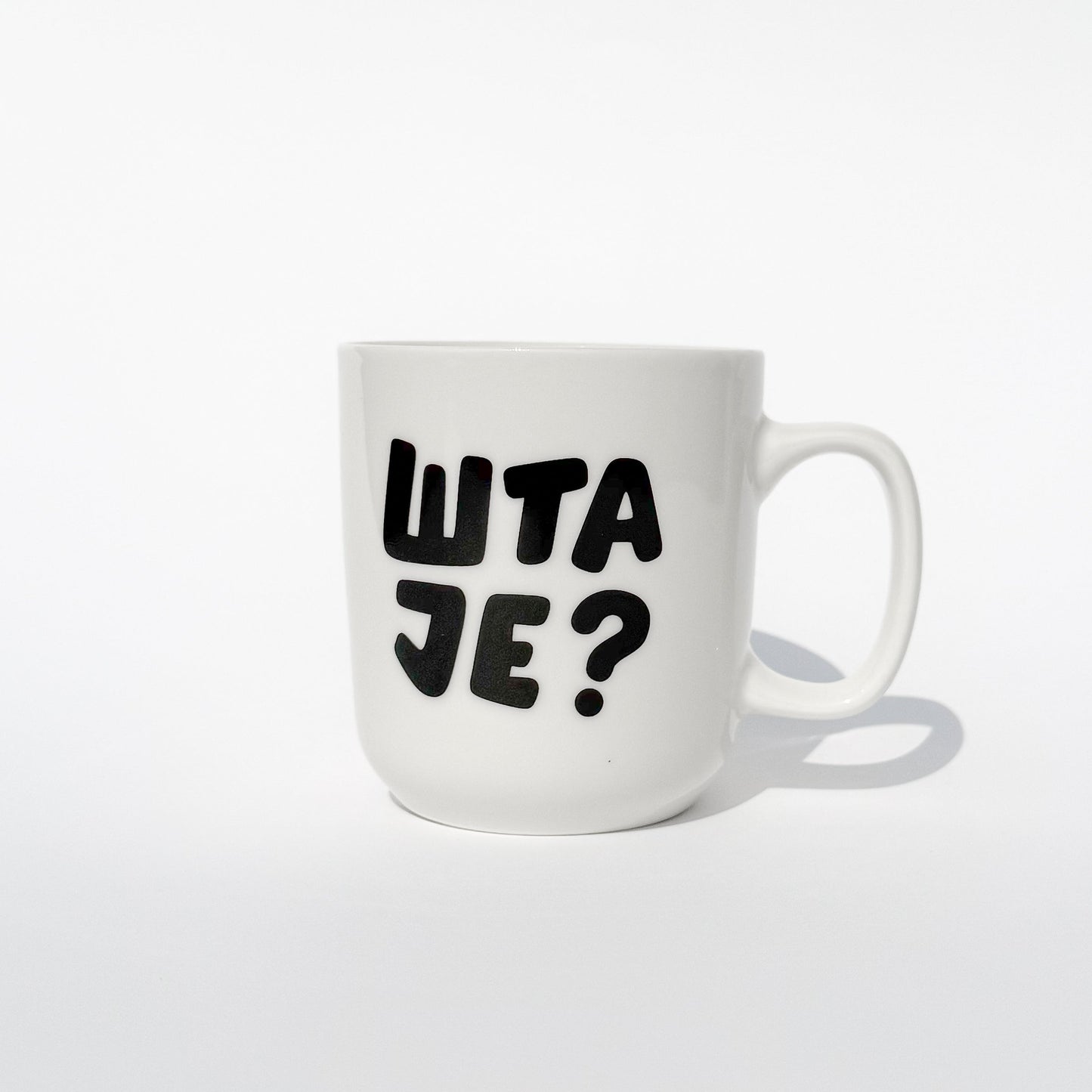 bela keramička šolja sa ćiriličnim, crnim natpisom šta je?